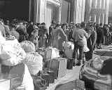 In San Francisco, residents of Japanese ancestry await a bus (1942).